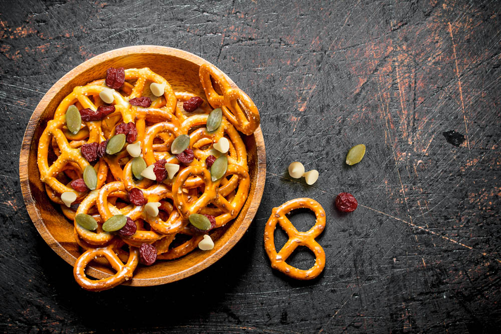 Snacks pretzels in a bowl. On dark rustic background