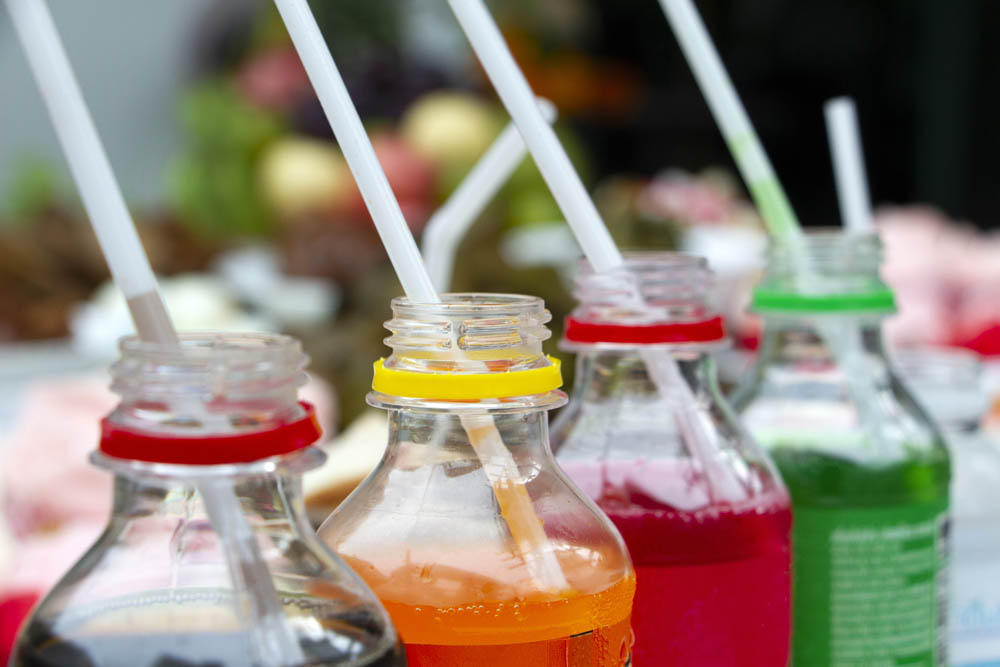 Colorful of carbonated soft drink pop soda bottles with plastic straw. Plastic bottles of assorted carbonated in variety of colors.