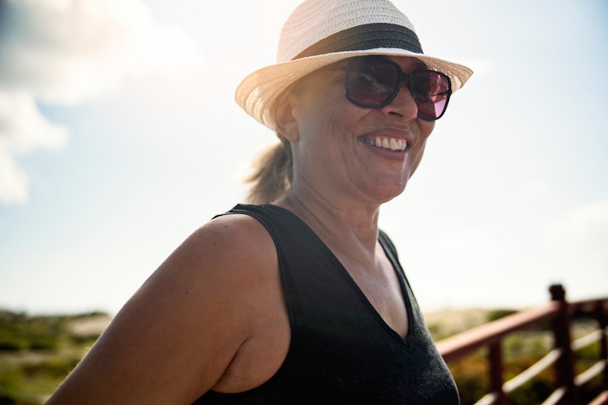 Woman in the sun wearing sunglasses and hat 