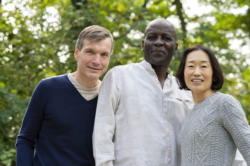 Mid-shot of three diverse friends hanging out together outdoors in public park