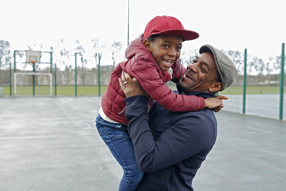 Father and son laughing and playing in the park together