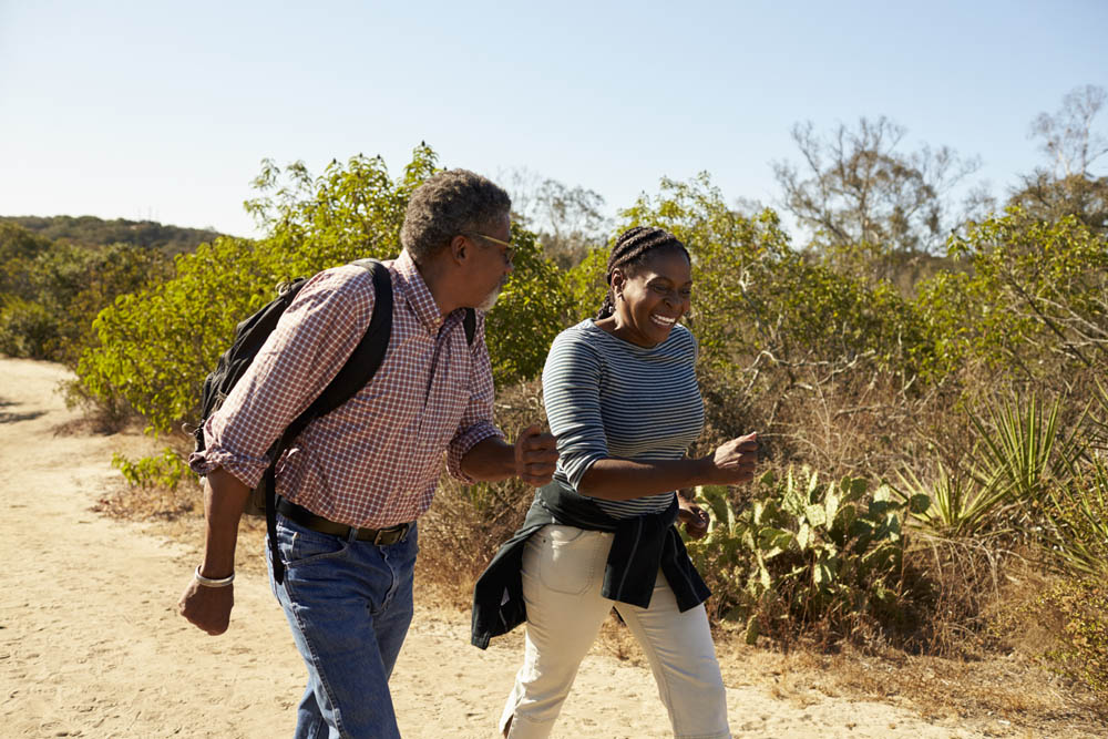 Mature Couple Hiking Outdoors In Countryside Together