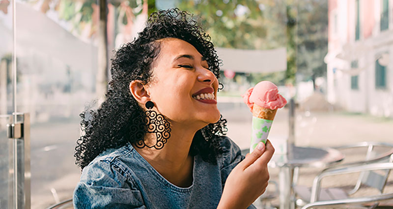 Woman enjoying an ice cream cone outdoors.