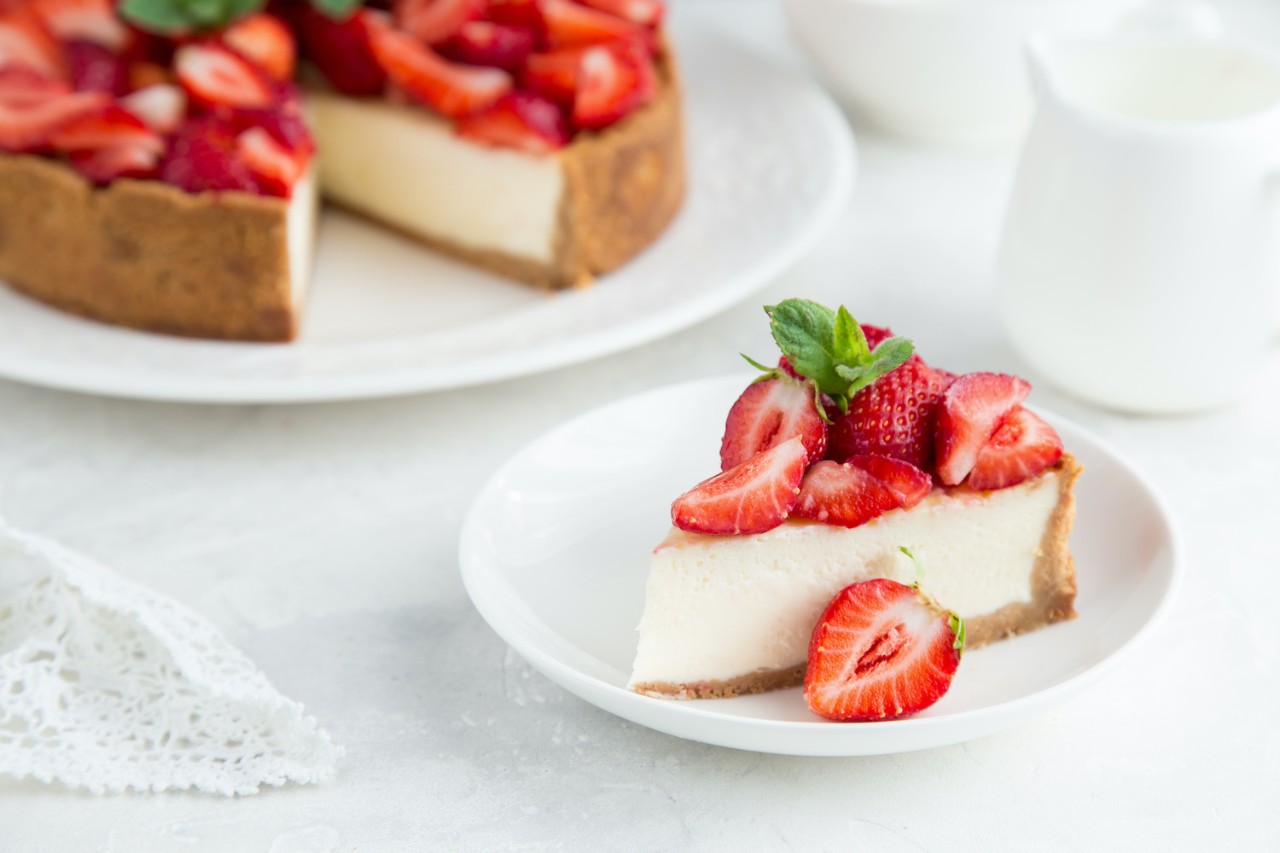 slice of strawberry cheesecake on white background, selective focus, square image