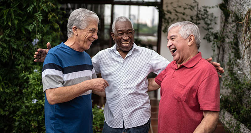  Three older men enjoying a lively conversation outdoors, laughing and sharing a moment of camaraderie