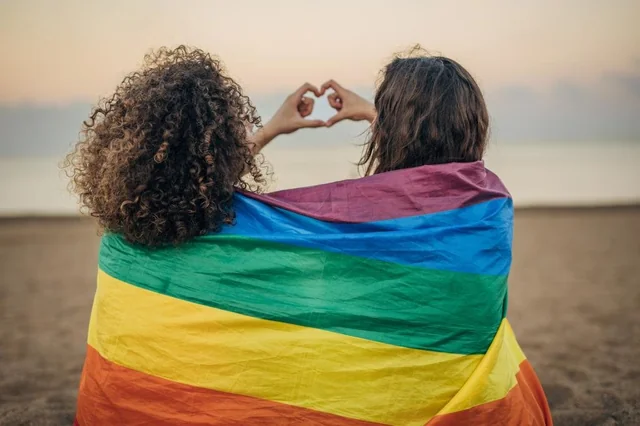 Women hugging in rainbow flag