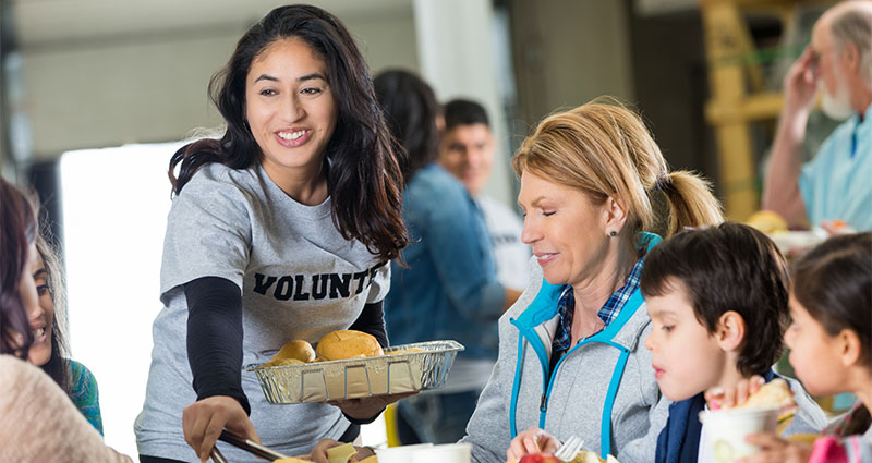 Woman serving food while volunteering. 