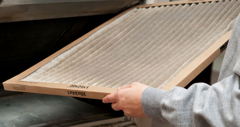 Image of someone carrying a furnace filter.