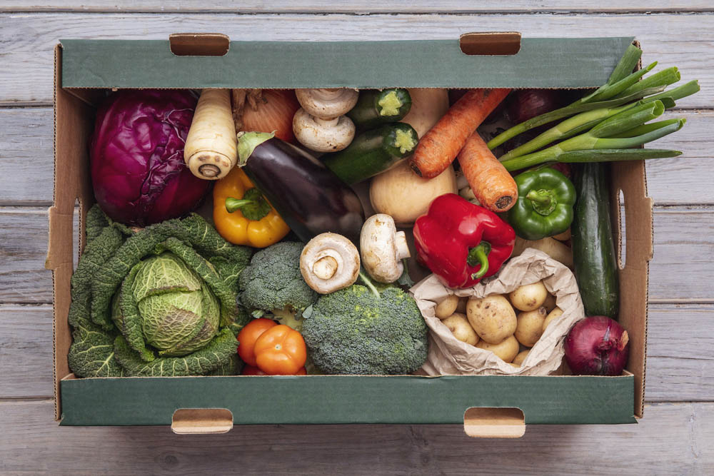 Fresh organic vegetable delivery box on a wooden background