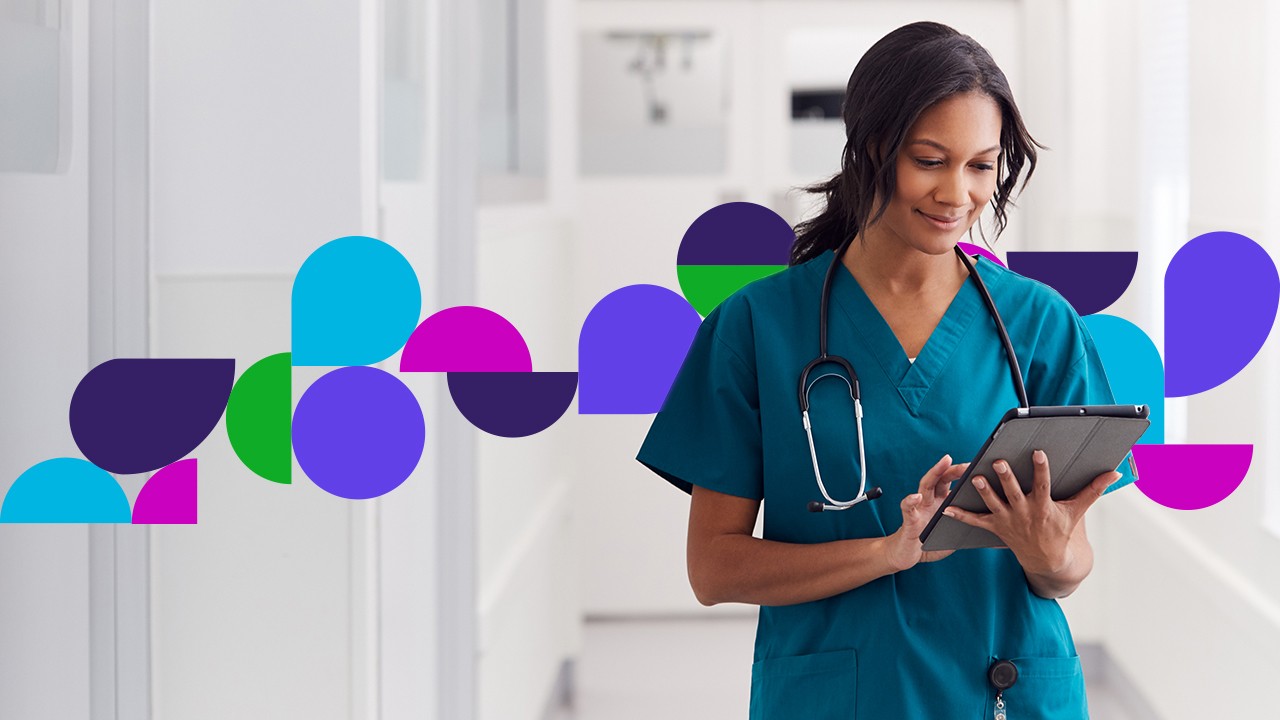 Medical professional in hallway looking at tablet