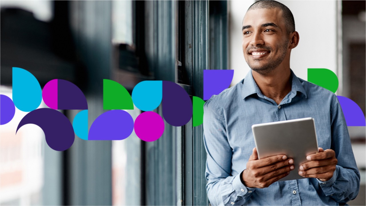Man smiling looking out the window while holding tablet