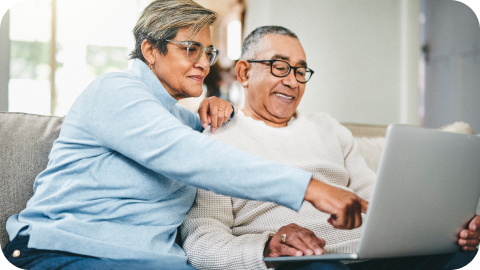 Couple sitting on couch looking at laptop