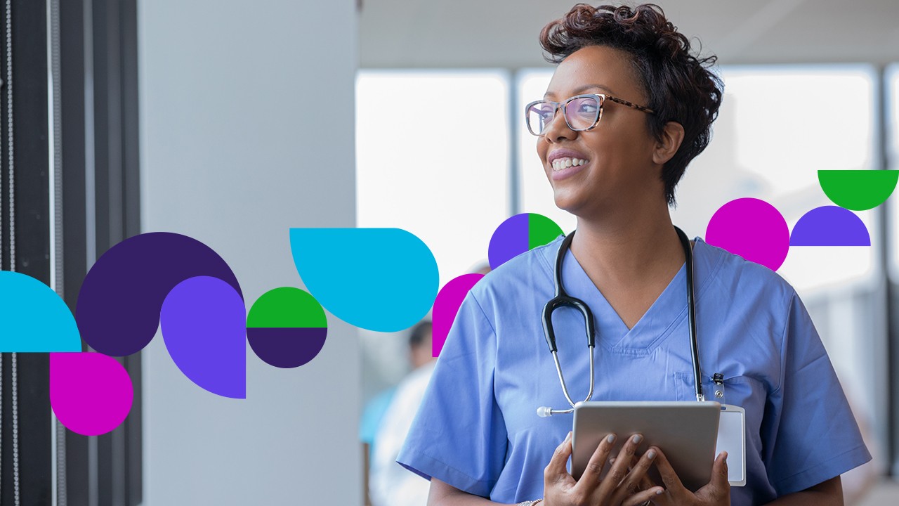 Medical professional holding a tablet looking out a window