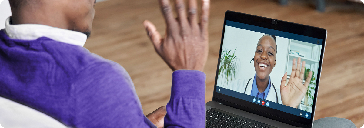 Person waving during a video call on a laptop