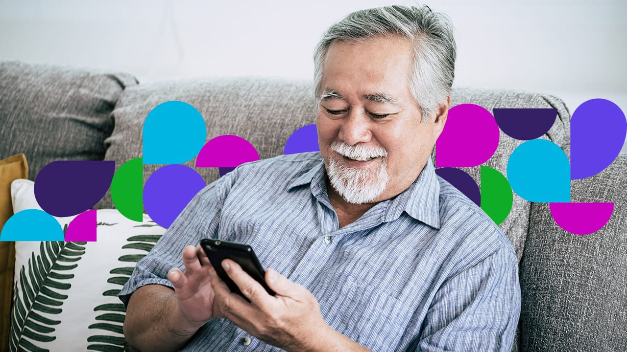 Man smiling sitting couch looking at cell phone
