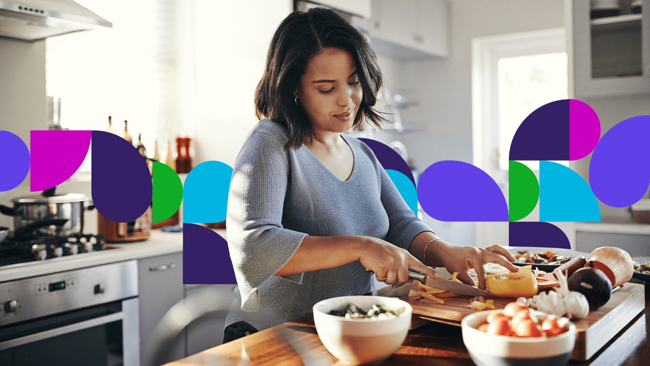 Woman cutting food on cutting board in kitchen