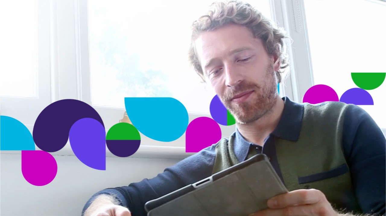 Man sitting on couch looking at tablet