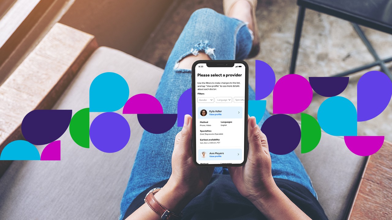 Person holding phone showing Teladoc Health app on screen