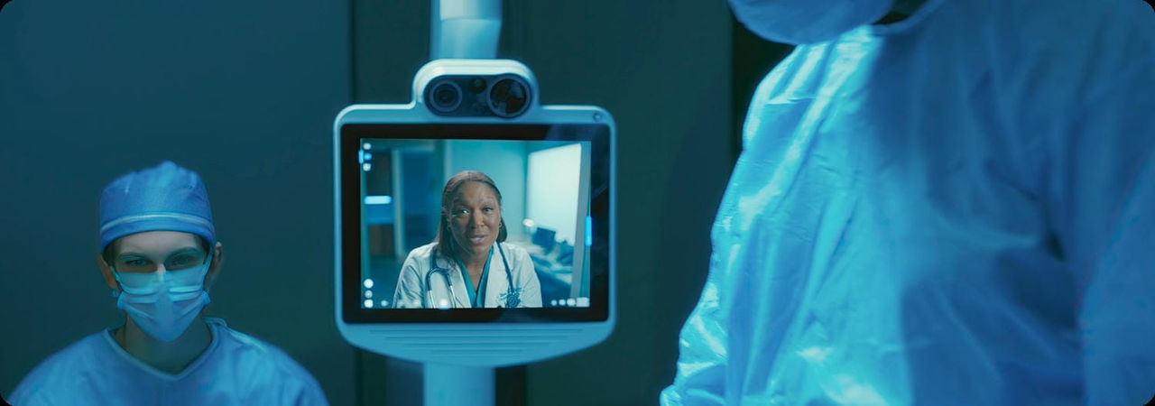 Medical professionals in an operating room, with a virtual consultation