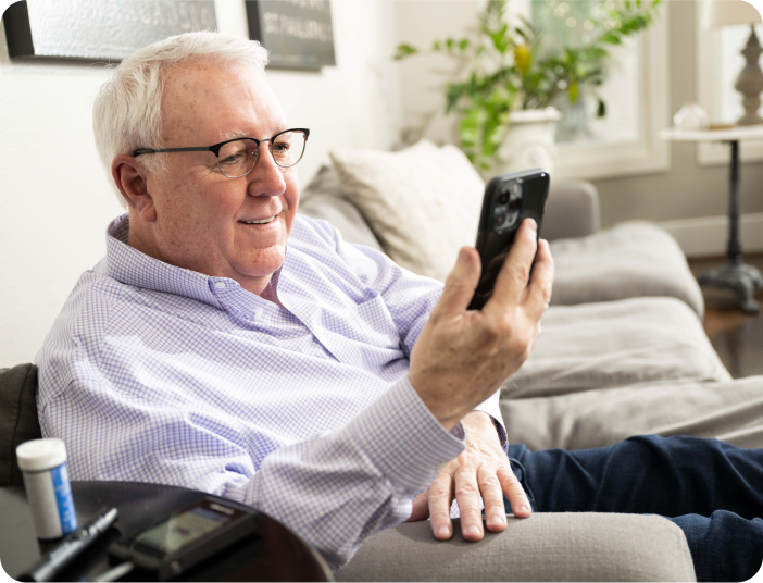 Older man sitting in chair looking at phone