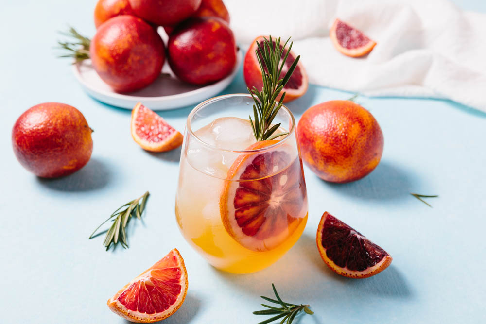 Delicious Blood Orange Cocktail on light blue background. Summer cocktails, refreshing drinks, low alcohol mocktail concept