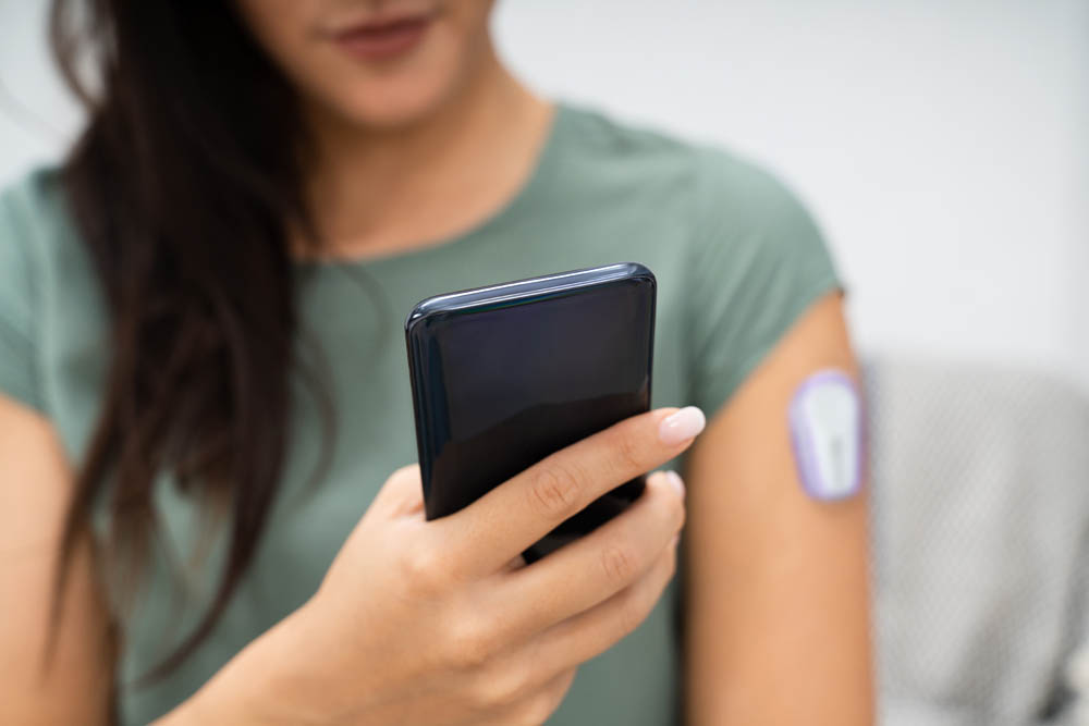 Woman Holding Smartphone In Hand With Bad Level Of Blood Sugar On The Screen