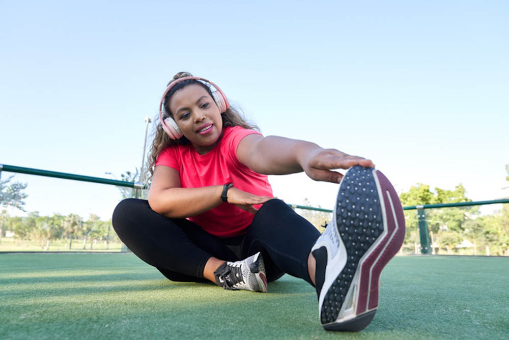 Woman with headphones on stretching
